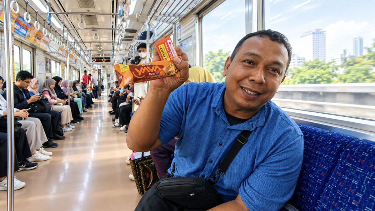Penumpang kereta antusias menikmati camilan sehat YA'Bar Very Berry di tengah perjalanan rute Sudirman-Bekasi.